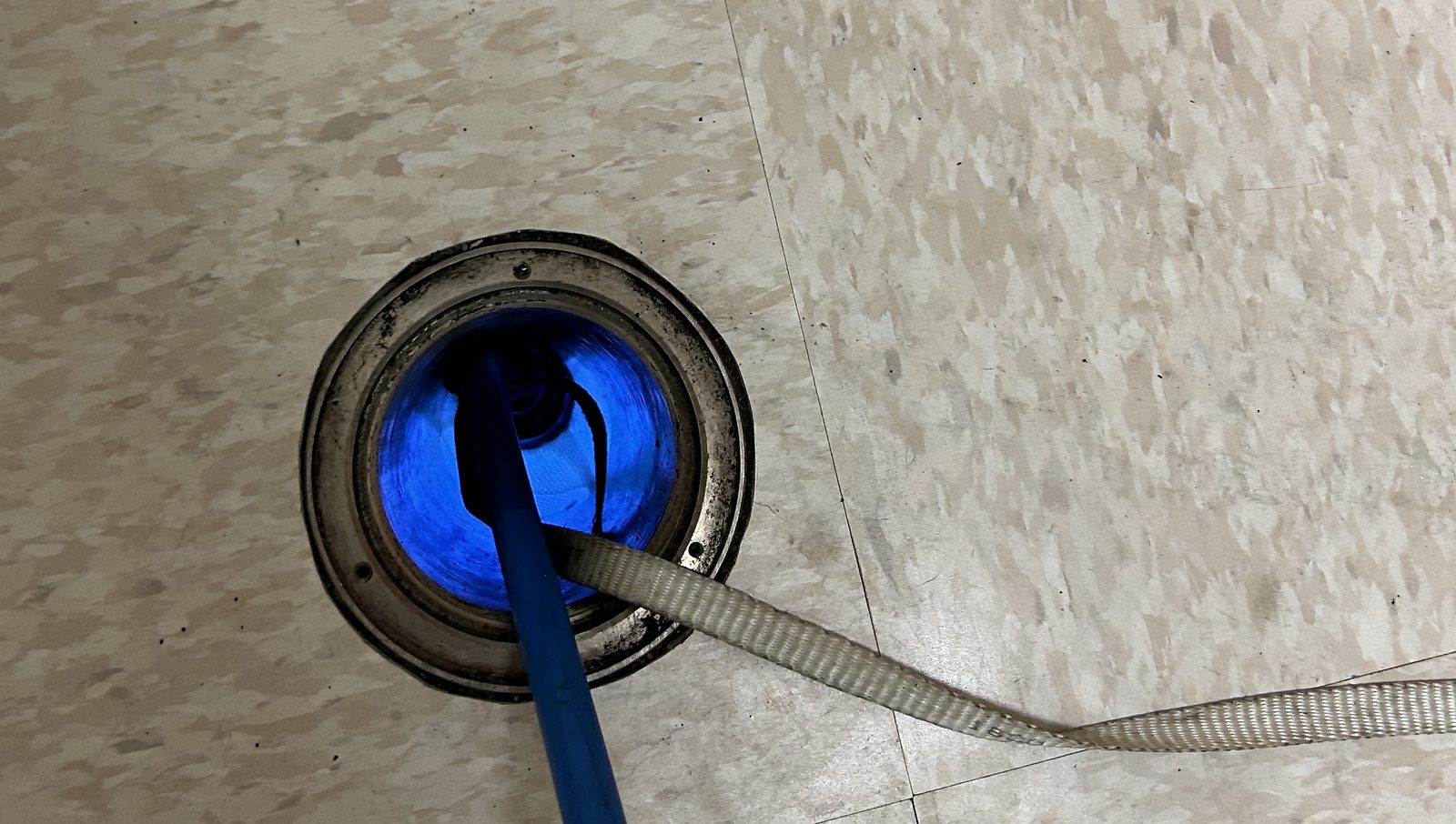 UV light curing a pipe liner, glowing through a floor cleanout